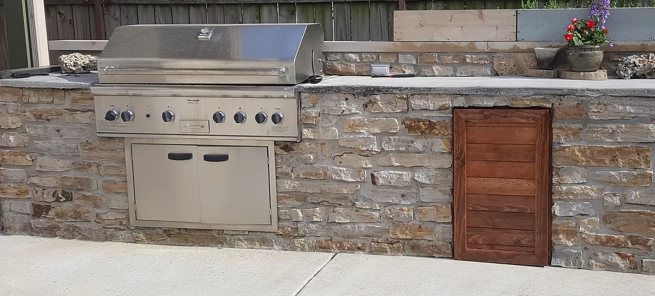 Custom outdoor kitchen with stacked stone surround and built-in grill, Honolulu.